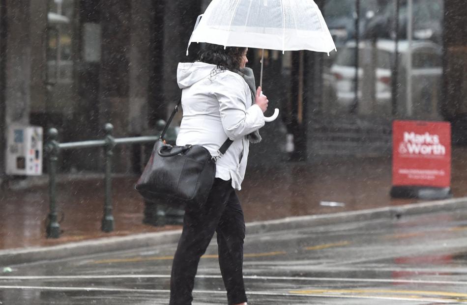 A pedestrian negotiates rain and wind in Lower Stuart St on Tuesday morning. PHOTO: GREGOR...