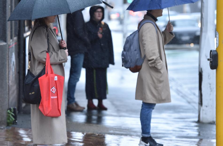 Pedestrians wait to cross Cumberland St in the rain on Tuesday morning. PHOTO: GREGOR RICHARDSON