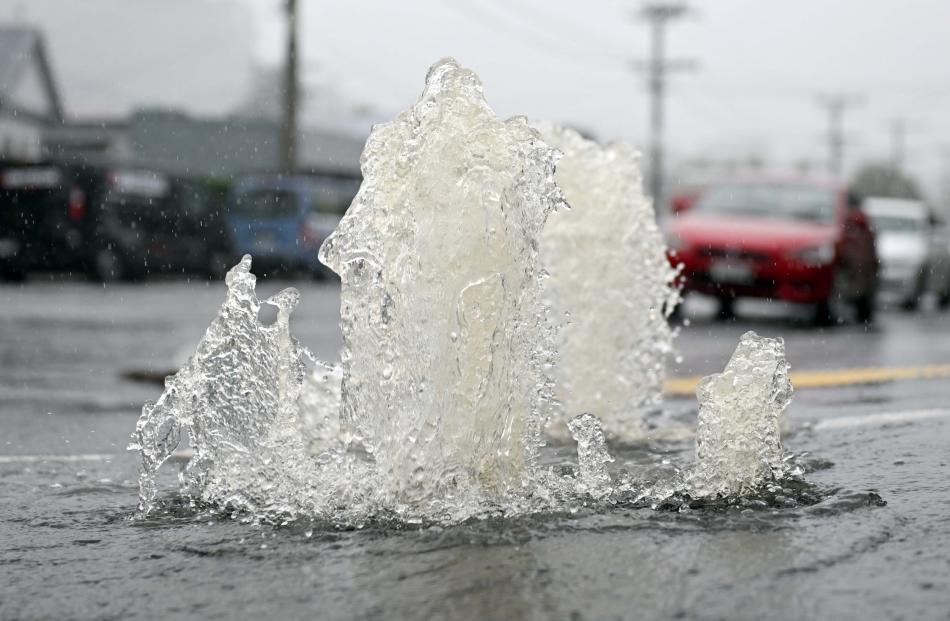 Water springs up from a manhole cover at the bottom of Blacks Rd, North East Valley. PHOTO:...