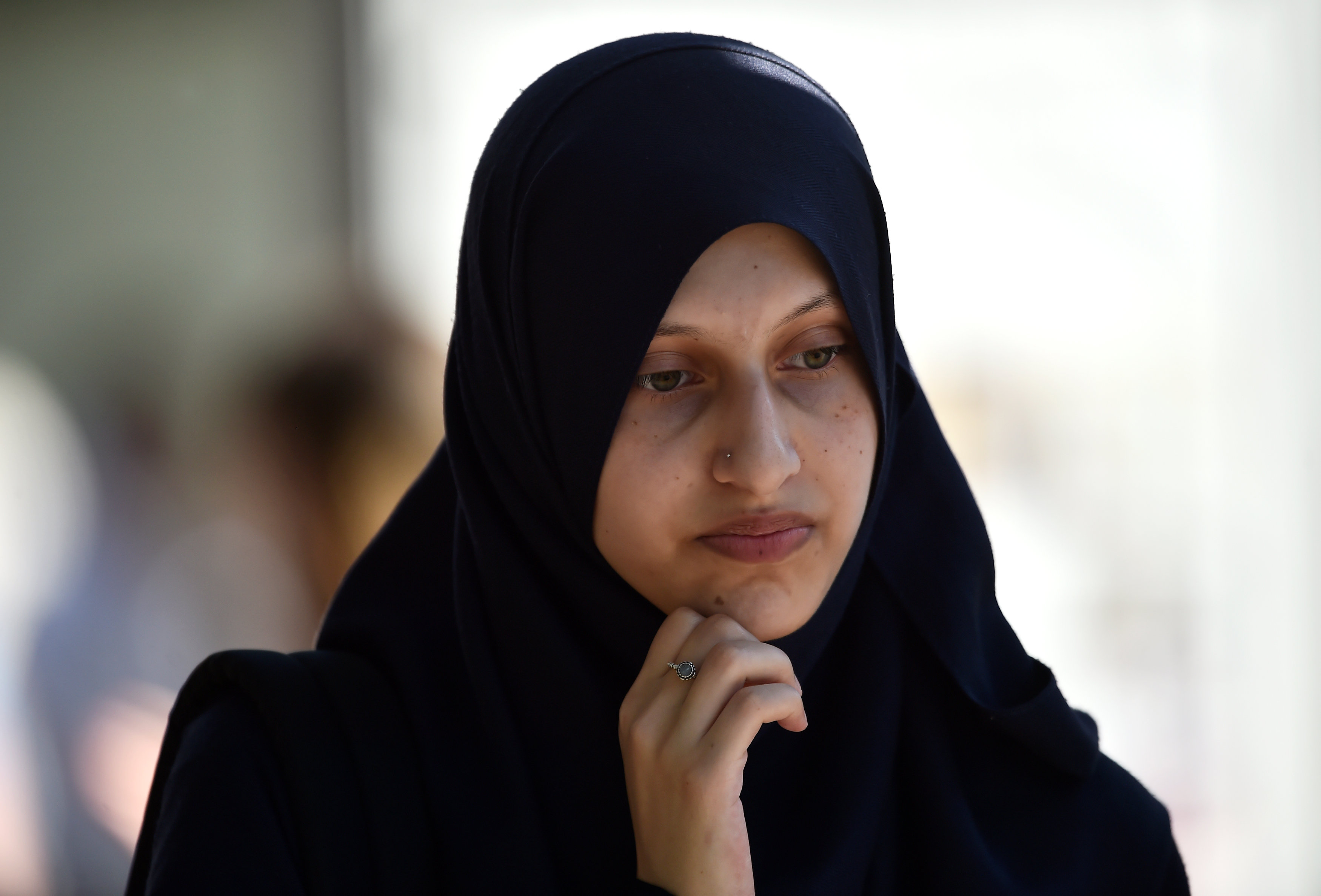 A woman in muslim dress stands at a bus stop near the scene of an attack where a van was driven...