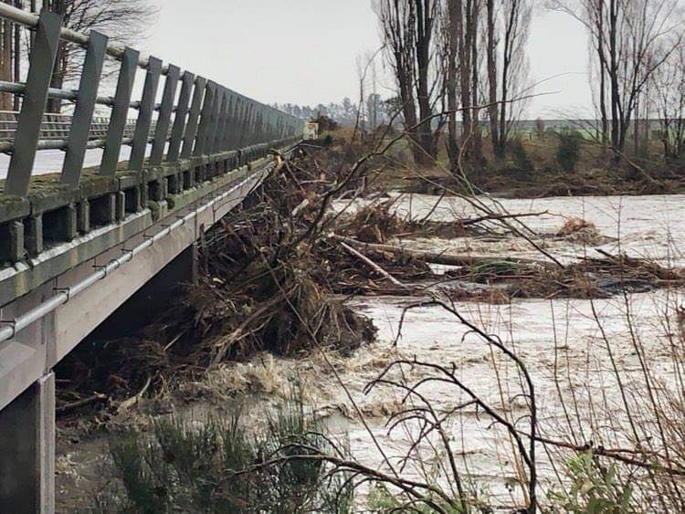 Debris carried by floodwater piles up against a bridge over the north branch of the Ashburton...