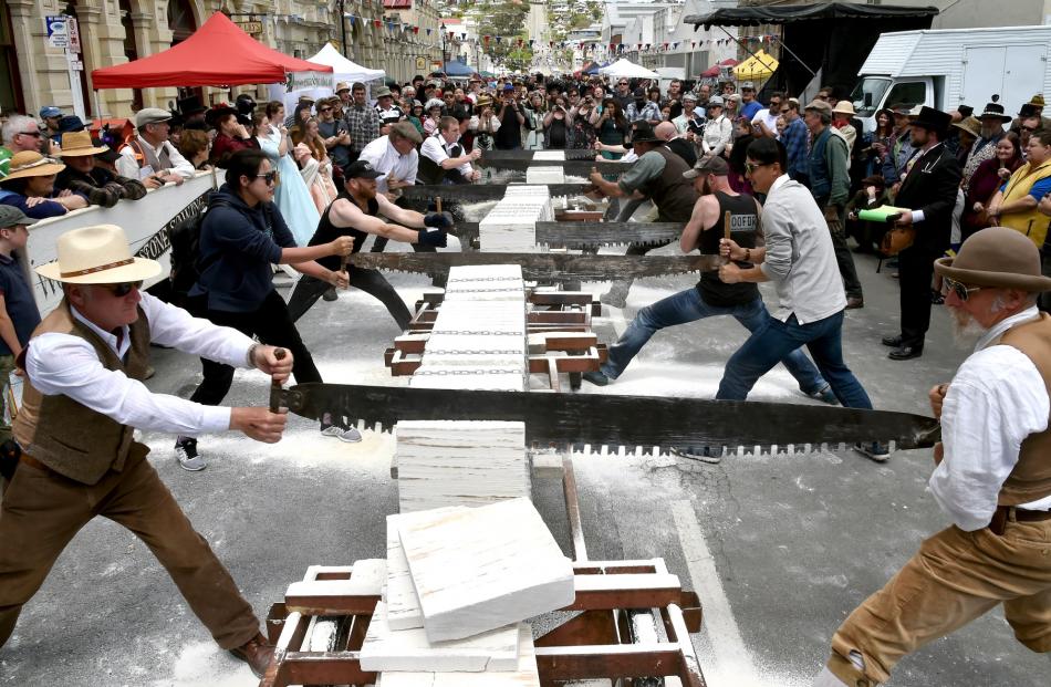 Competitors race to the bottom of a block of Oamaru stone in the stone-sawing event last year....