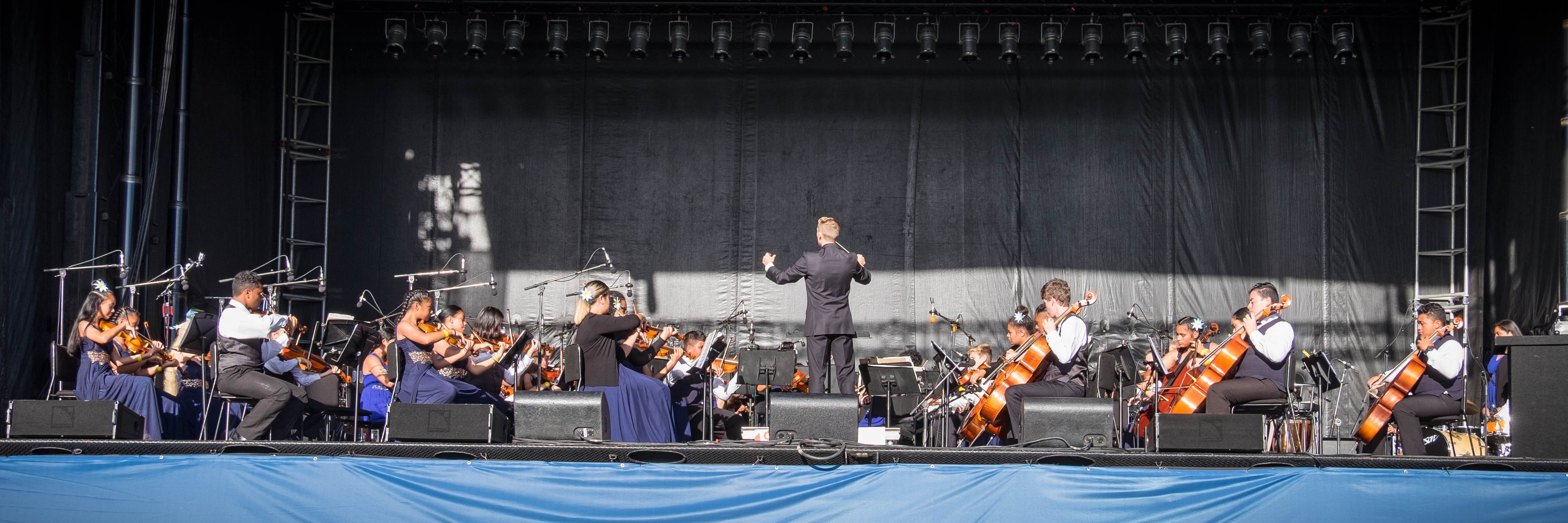 The Virtuoso String Orchestra playing in the Symphony at the Park at the Jerry Collins Stadium,...