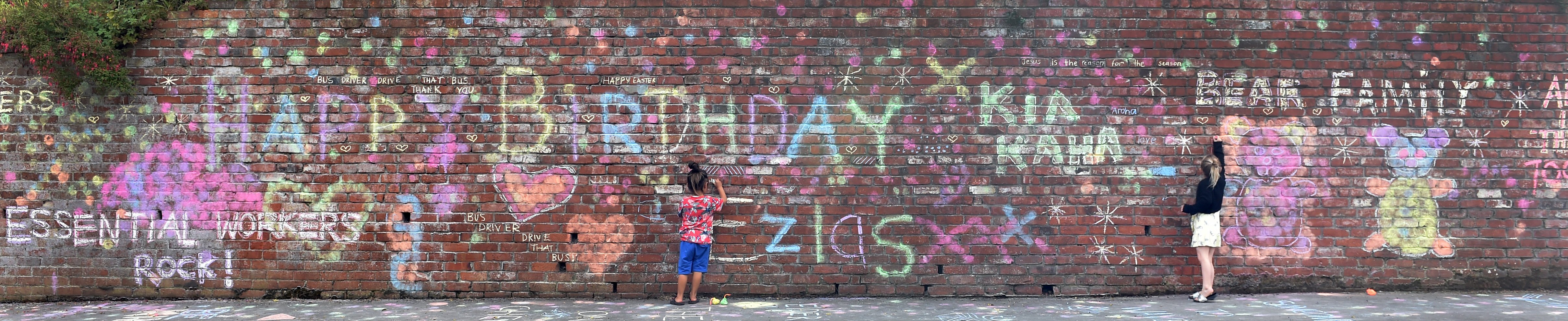 Ezias Kutia (left, 4) and Addisyn Martin (6) write messages of thanks to essential workers in...