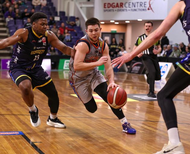Southland Sharks guard Rylan Jones looks for a way around Otago Nuggets point guard Alain Louis...